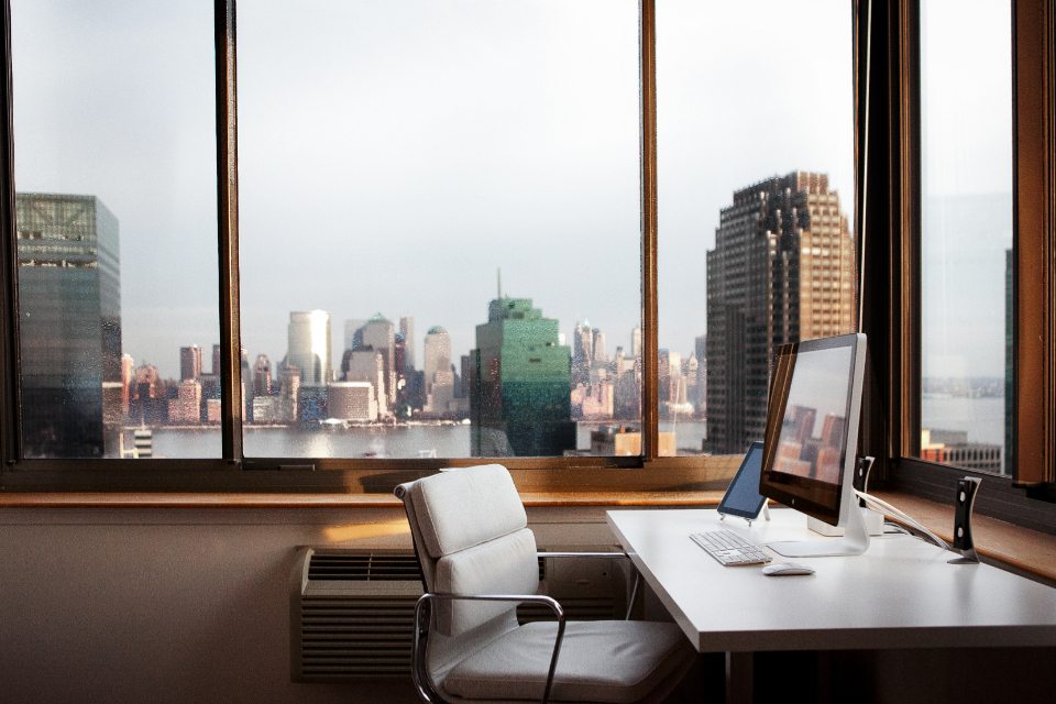 Escritório com computador e vista para a cidade
