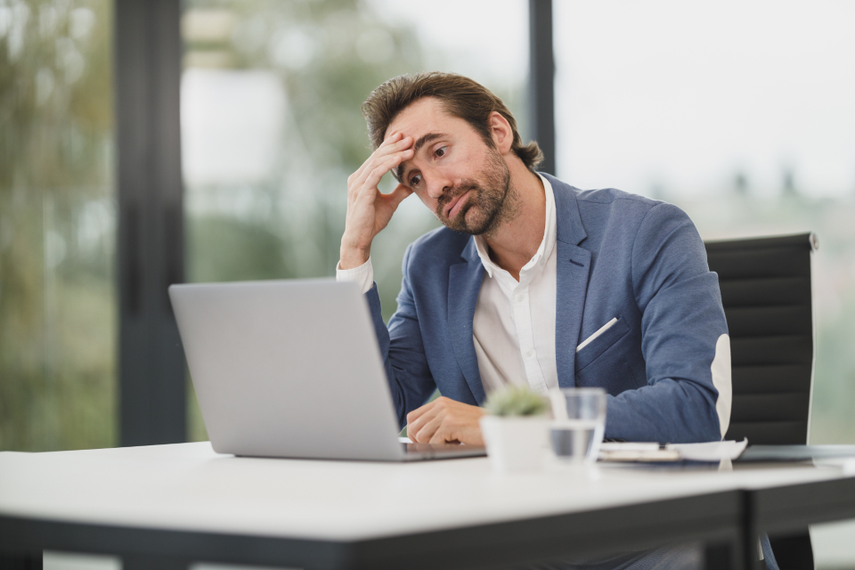 Empreendedor preocupado em frente ao notebook